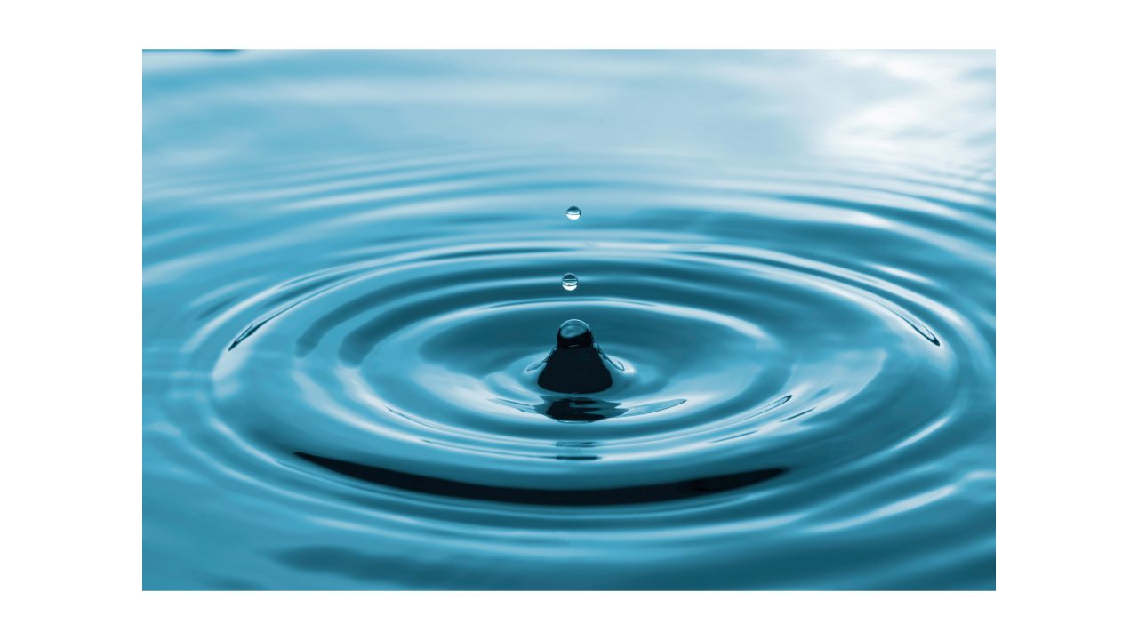 Water droplet making ripples on a calm surface